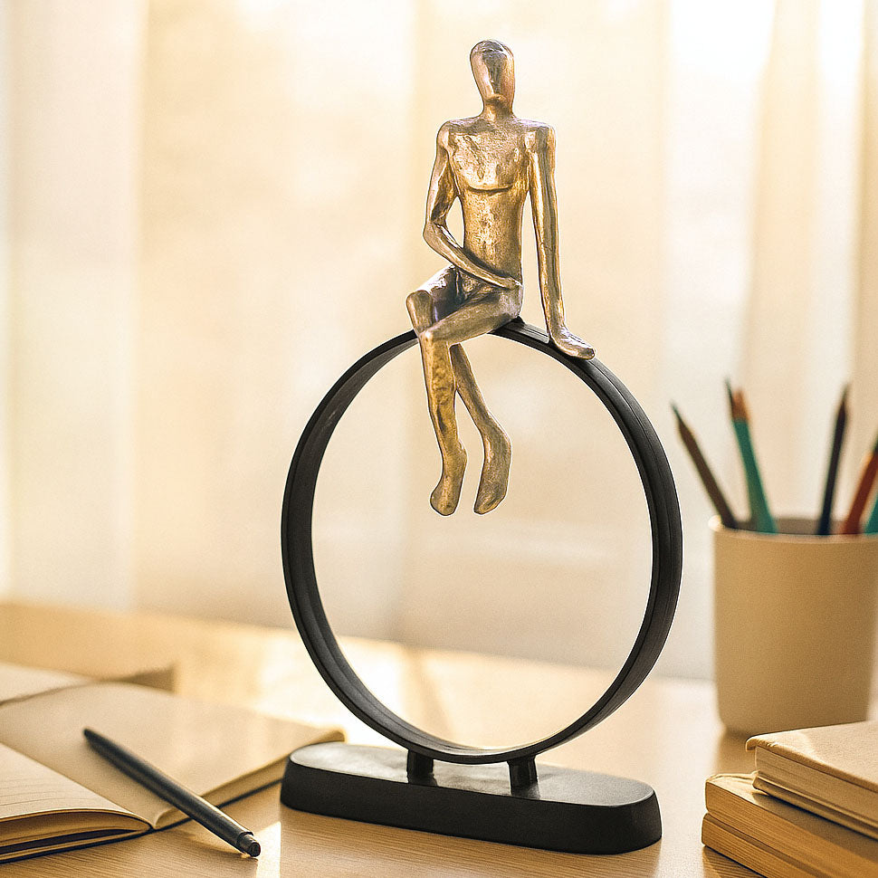 Man Sitting On Cirque Decorative Metal Showpiece- Black & Gold